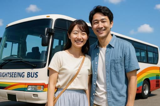 観光バスの前でポーズする夫婦 観光バスの前でポーズする夫婦の写真