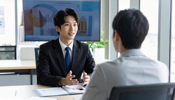 オフィスで商談する日本人ビジネスマン オフィスで商談する日本人ビジネスマンの写真