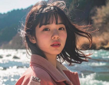 川辺で風に吹かれる女性 川辺で風に吹かれる女性の写真