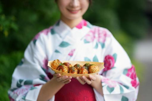 浴衣姿の女性がたこ焼きを差し出す たこ焼き,食べ物,持つの写真素材