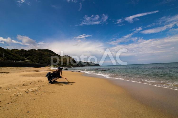 砂浜に絵を描く女性 砂浜,海,砂の写真素材