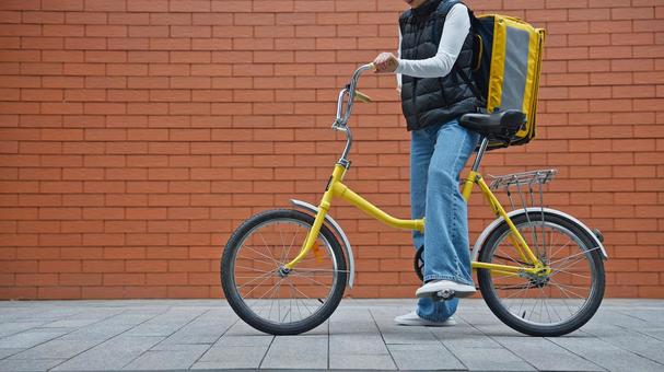 自転車にまたがるフードデリバリーの女性 配達,フードデリバリー,デリバリーの写真素材