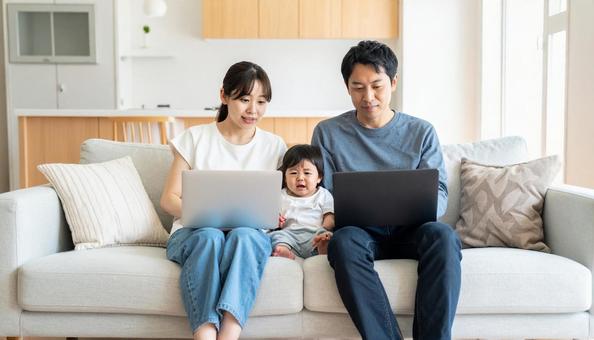 家でパソコンを使う日本人家族の写真