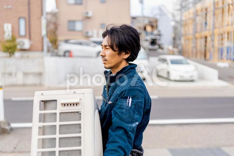 取り外した室外機を運ぶ作業員の男性 ビジネス,ビジネスマン,男の写真素材