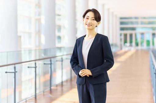 オフィスの通路に立つ女性社員 ビジネス オフィスの通路に立つ女性社員 ビジネス ビジネスウーマン,オフィス,笑顔の写真素材