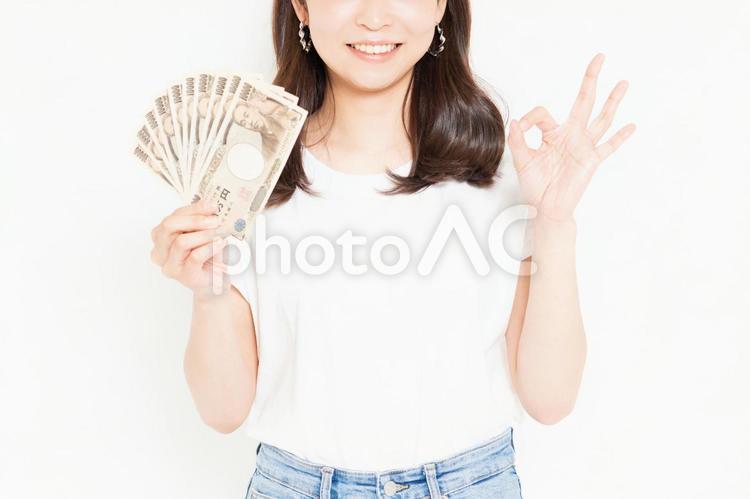 お金を持って喜んでいるTシャツを着た若い女性 お金,女性,金の写真素材