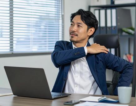 辛い肩凝りで苦しむ男性の写真
