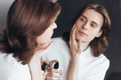 鏡を見ながら乳液を塗る男性 男性,外国人,欧米人の写真素材