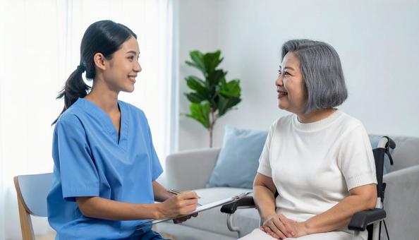 シニア女性に聞き取りをする若い介護士 シニア女性に聞き取りをする若い介護士の写真