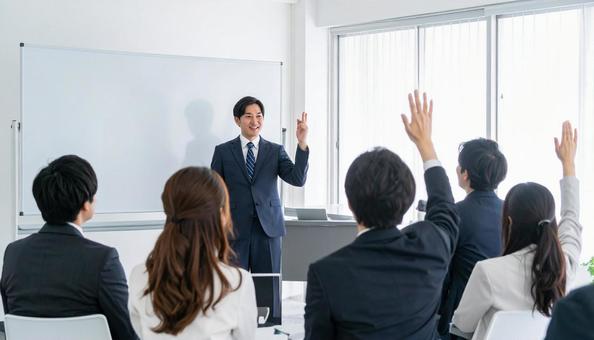 セミナー・プレゼンをする講師と挙手する人の写真
