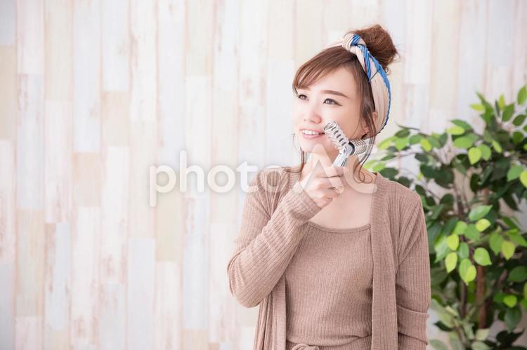 ルームウェアの女性 美顔器,たるみ,マッサージの写真素材