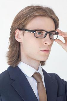 メガネに手をやるスーツを着た男性 男性,外国人,欧米人の写真素材