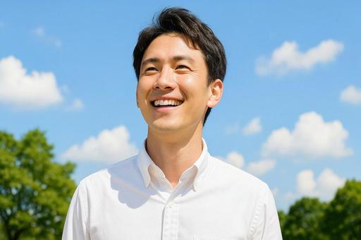青空の下で仕事中の爽やかの笑顔の男性 青空の下で仕事中の爽やかの笑顔の男性の写真