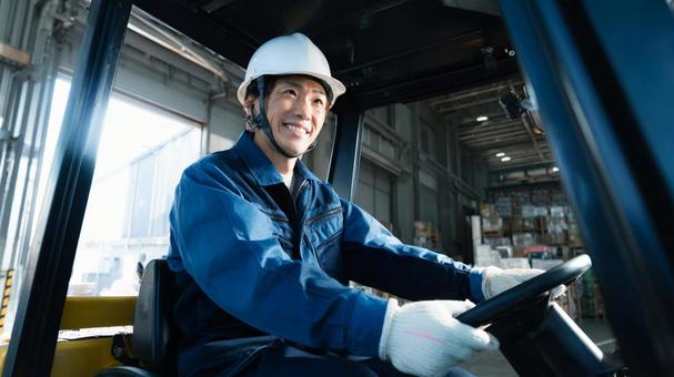 倉庫で運転中の作業員 倉庫で運転中の作業員の写真