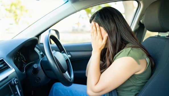 車を運転中、不安そうな女性 車を運転中、不安そうな女性の写真