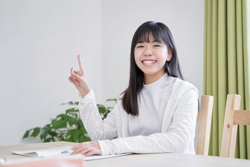 A junior high school girl pointing with a smile in the living room, JPG A junior high school girl pointing with a smile in the living room, JPG