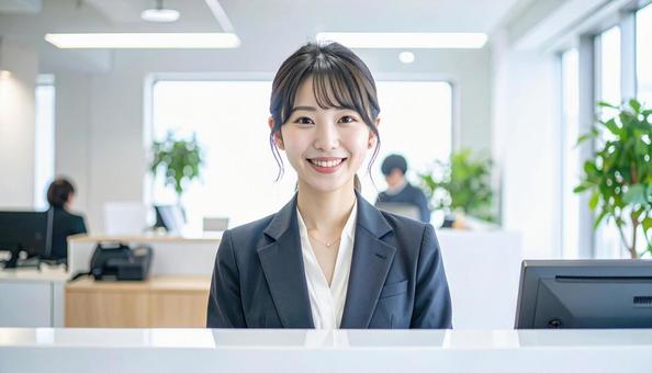 笑顔で対応する女性の受付嬢 笑顔で対応する女性の受付嬢の写真