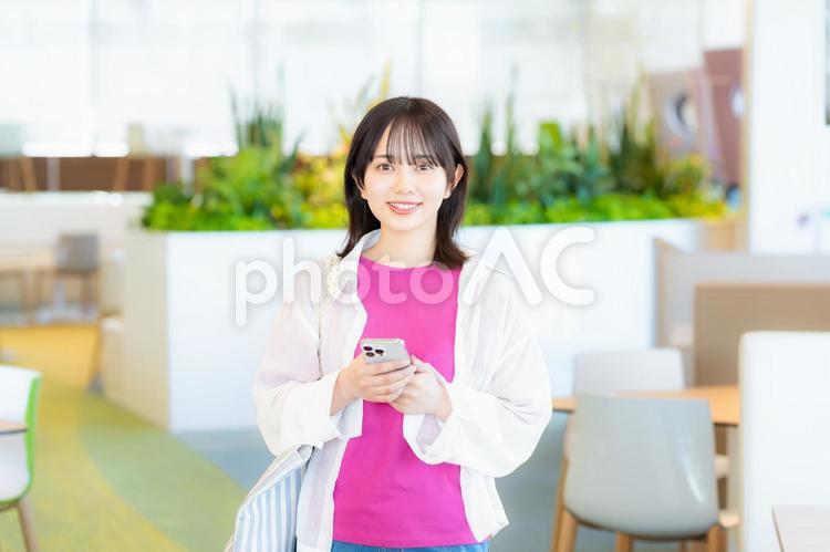 スマホを見る笑顔の女性 スマホ,若い女性,笑顔の写真素材