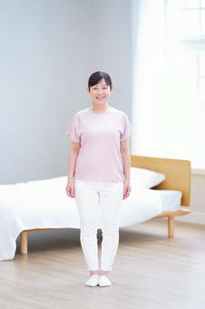 ピンクの服で微笑む中年女性の全身ポートレート ピンクの服で微笑む中年女性の全身ポートレート 主婦,シニア,立ち姿の写真素材
