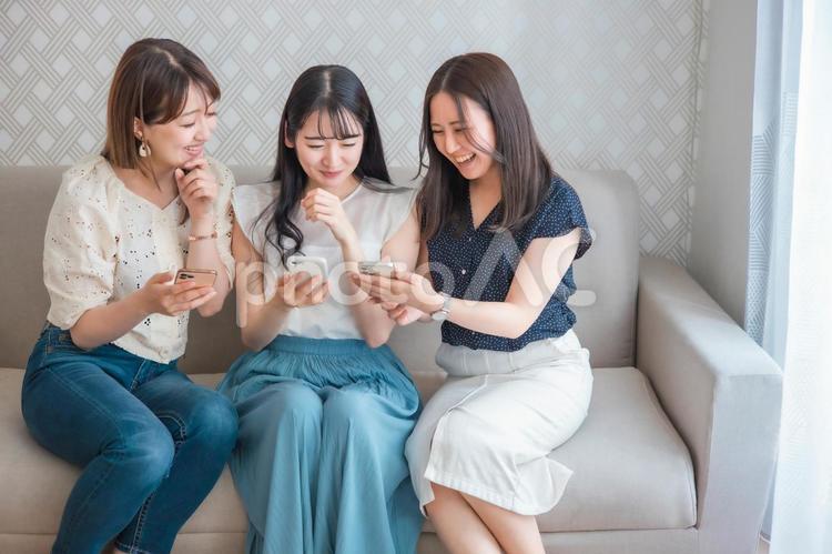 スマホを使う女性たち（爆笑） スマートフォン,スマホ,女子会の写真素材