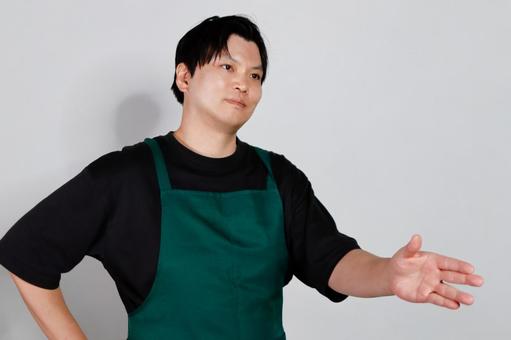エプロン姿の男性指差し 男性,エプロン,黒い服の写真素材