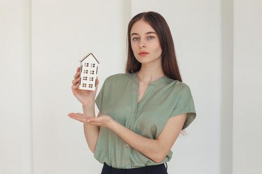 家の模型を紹介する女性スタッフ 保険業,事務職,接客業の写真素材