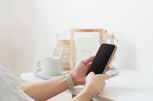 スマホを持つ手(黒画面)_白空間両手 スマホを持つ手(黒画面)_白空間両手の写真