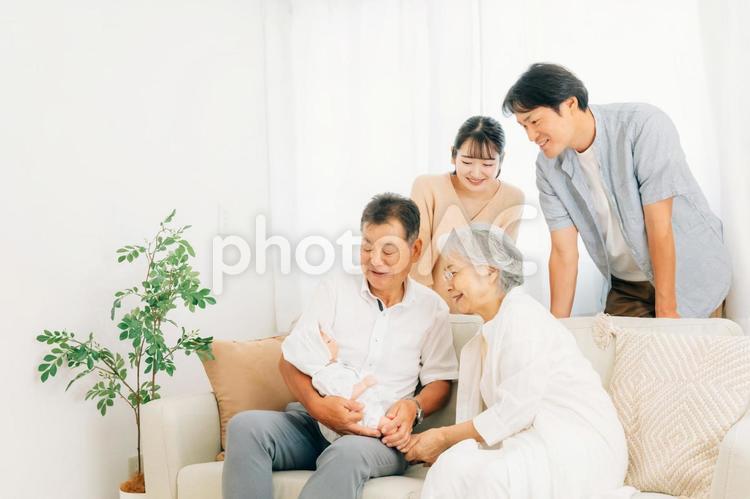 赤ちゃんを抱いた夫婦と老夫婦（里帰り） 孫,里帰り,帰省の写真素材