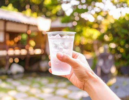 一杯の飲み物を手に取る日本人男性の手の写真