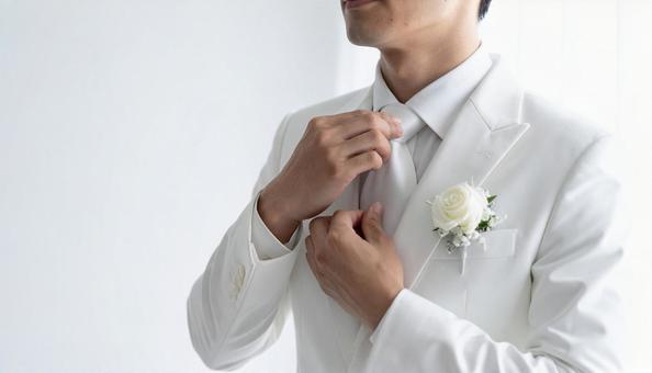 白いネクタイを直すタキシード姿の花婿の写真