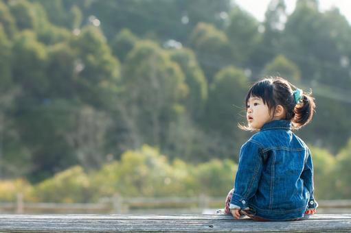 ベンチに座って遠くを見つめる子供 ベンチに座って遠くを見つめる子供 子供,公園,ベンチの写真素材