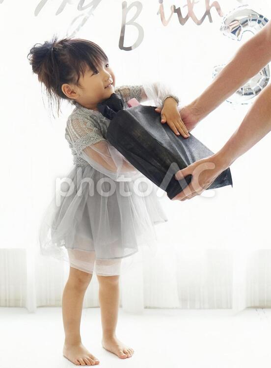 誕生日プレゼントをもらう女の子 誕生日,プレゼント,笑顔の写真素材