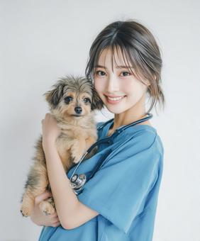 子犬を抱く笑顔の若い女性獣医師 子犬を抱く笑顔の若い女性獣医師の写真