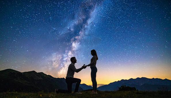 星空の下でプロポーズする男性と女性 星空の下でプロポーズする男性と女性の写真