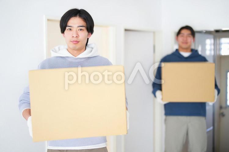 引っ越しの段ボール箱を持って立っている2人の男性 引っ越し,一人暮らし,男性の写真素材
