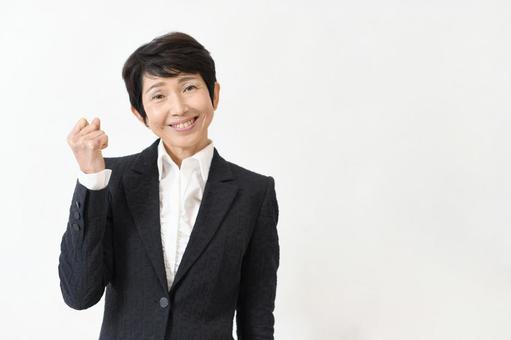 A middle-aged woman in a suit gives a fist pump, JPG A middle-aged woman in a suit gives a fist pump, JPG