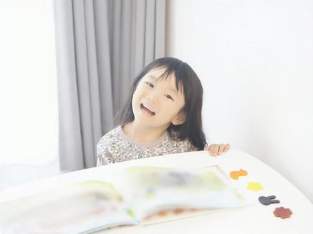 微笑著看圖畫書的女孩 微笑著看圖畫書的女孩