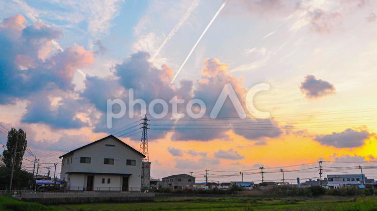 夕暮れ時　グラデーションの空とポツンとたたずむ家 飛行機雲,家,田舎の写真素材