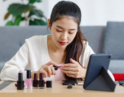 指にネイルを塗る女性 指にネイルを塗る女性の写真