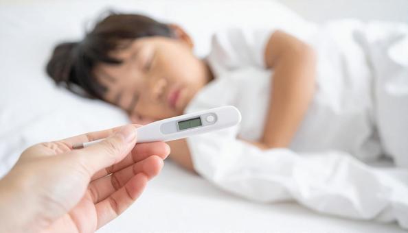 体温計を持つ母親の手と体調不良の子供 体温計を持つ母親の手と体調不良の子供の写真
