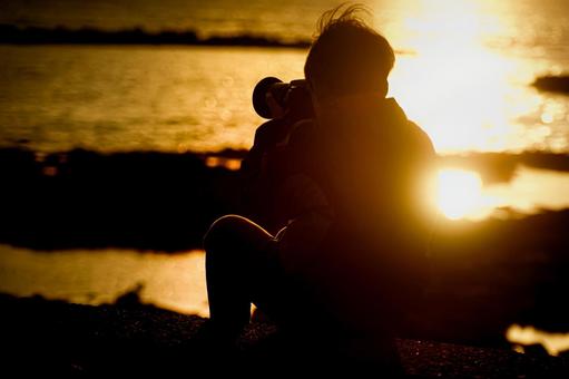 ＜素材＞日没の海をカメラで撮影する男の子 子供,海,サンセットの写真素材
