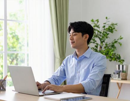 集中してパソコン作業する男性の写真