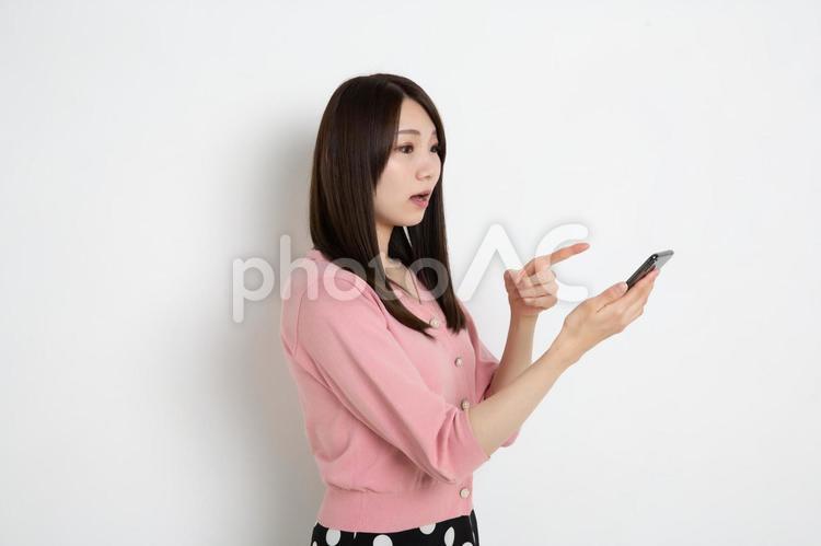 スマートフォンで検索をしているものを見つけた若い女性 女性,日本人,女の写真素材