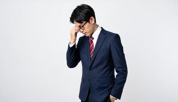ビジネスイメージ うつむき悩む日本人男性 ビジネスイメージ うつむき悩む日本人男性の写真