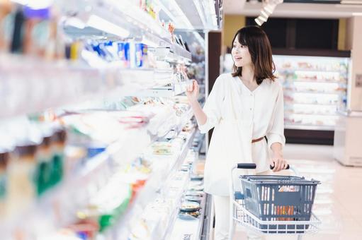 スーパーで食料品を買う若い女性 スーパーで食料品を買う若い女性 スーパーマーケット,チェック,食料品の写真素材
