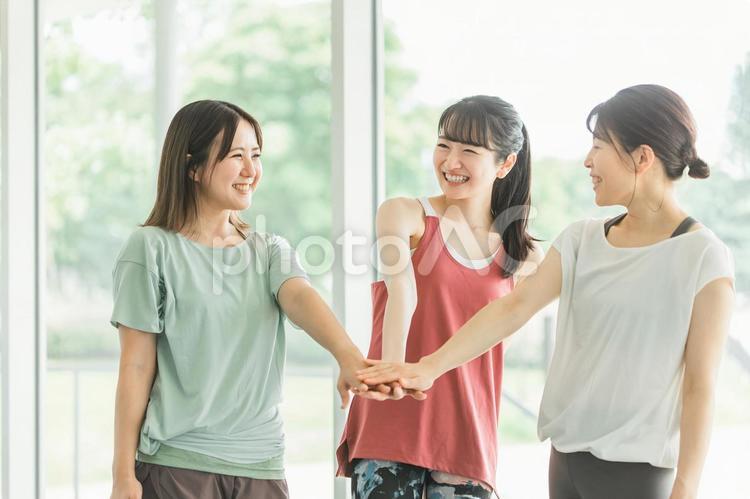 ジムで仲間と円陣を組むアジア人の女性達 ヨガ,スポーツジム,ピラティスの写真素材