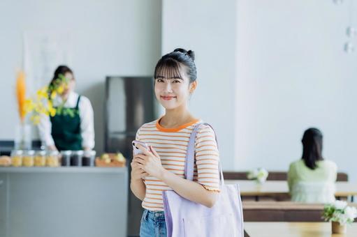 カフェに来店する若い女性 カフェに来店する若い女性 カフェ,女性,笑顔の写真素材
