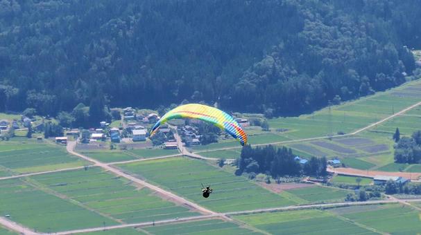 白馬村上空を飛ぶパラグライダー 白馬村上空を飛ぶパラグライダー パラグライダー,アクティビティー,夏の写真素材