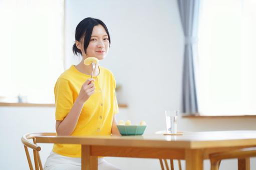 嬉しそうにカメラ目線でフォークを持つ女性 女性,リンゴ,フォークの写真素材