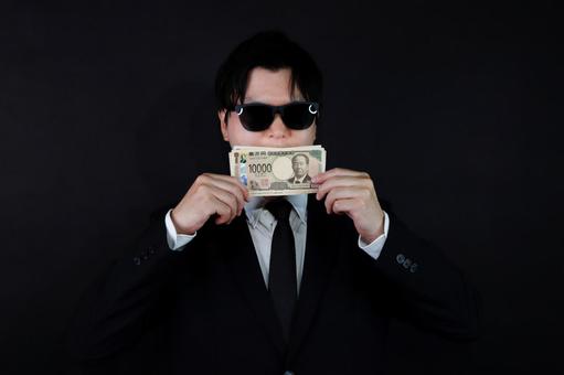 サングラスと一万円札の男性 サングラスと一万円札の男性の写真